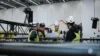 Unsere Mitarbeiter tragen Arbeits- und Schutzkleidung. Sie stehen zwischen Traversen und planen die Umsetzung der Technik.