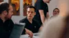Unsere Mitarbeitenden sitzen an einem Tisch und unterhalten sich. Ein Laptop ist ebenfalls zu sehen.