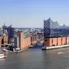 Die Elbphilharmonie und die Elbe sind zu sehen. Im Hintergrund sieht man die Stadt Hamburg.