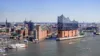 Die Elbphilharmonie und die Elbe sind zu sehen. Im Hintergrund sieht man die Stadt Hamburg.