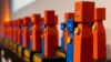 Kleine rote und blaue Figuren aus Holz.